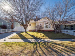 View of front of home featuring a fenced front yard, driveway, and a front lawn