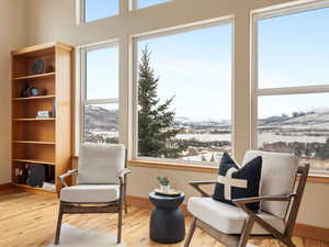 Living area featuring baseboards, wood finished floors, a mountain view, and a healthy amount of sunlight