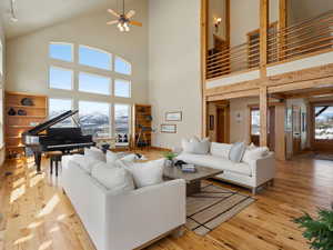 Living room with a ceiling fan, light wood-type flooring, and a mountain view