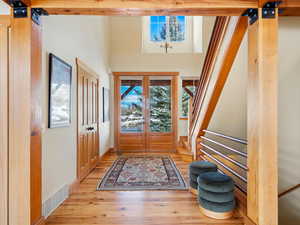 Foyer entrance featuring stairs, wood finished floors, visible vents, and baseboards