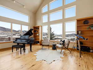 Living area with light wood-style floors, a healthy amount of sunlight, a mountain view, and baseboards