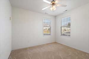 Empty room with baseboards, a textured ceiling, visible vents, and light colored carpet