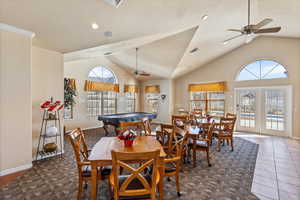 Dining room featuring french doors, dark tile patterned flooring, high vaulted ceiling, and visible vents