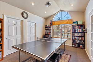 Playroom featuring baseboards, visible vents, carpet, vaulted ceiling, and a textured ceiling