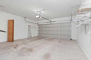 Garage featuring a garage door opener.  Garage fully painted.