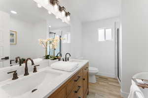 Primary en suite bathroom featuring double vanity, tub, and shower.