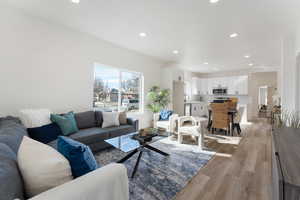 Living area with light wood-style floors and recessed lighting