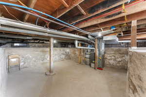 Unfinished basement featuring heating unit