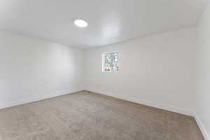 Carpeted empty room featuring baseboards