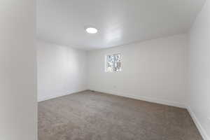 Carpeted spare room with baseboards