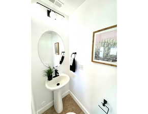 Bathroom with a textured ceiling, visible vents, and baseboards