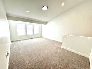 Carpeted spare room with recessed lighting and baseboards