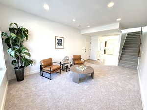 Living area featuring light carpet, stairway, and recessed lighting