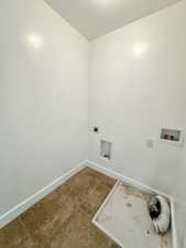 Laundry room featuring hookup for a washing machine, laundry area, baseboards, tile patterned floors, and electric dryer hookup