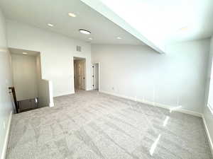 Unfurnished room featuring vaulted ceiling with beams, recessed lighting, light carpet, visible vents, and baseboards