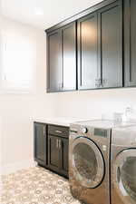 Washroom featuring cabinets and washer and dryer