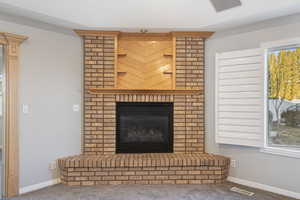 Room details with a brick fireplace and carpet floors