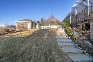 View of yard with an outdoor structure and a pergola