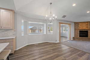 Unfurnished dining area featuring dark wood-type flooring and a fireplace