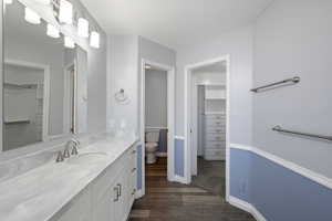 Bathroom with wood-type flooring, toilet, and vanity