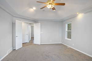 Unfurnished bedroom featuring ornamental molding, carpet, and ceiling fan