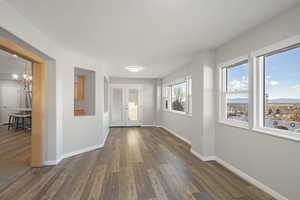 Foyer featuring an inviting chandelier, dark hardwood / wood-style floors, and french doors