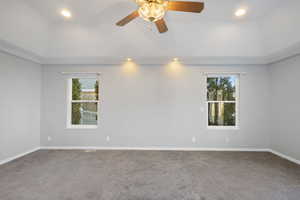 Carpeted empty room featuring ceiling fan and ornamental molding