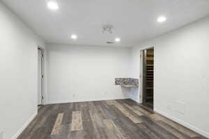 Empty room featuring dark hardwood / wood-style flooring