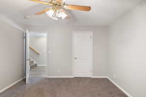 Carpeted empty room with ceiling fan