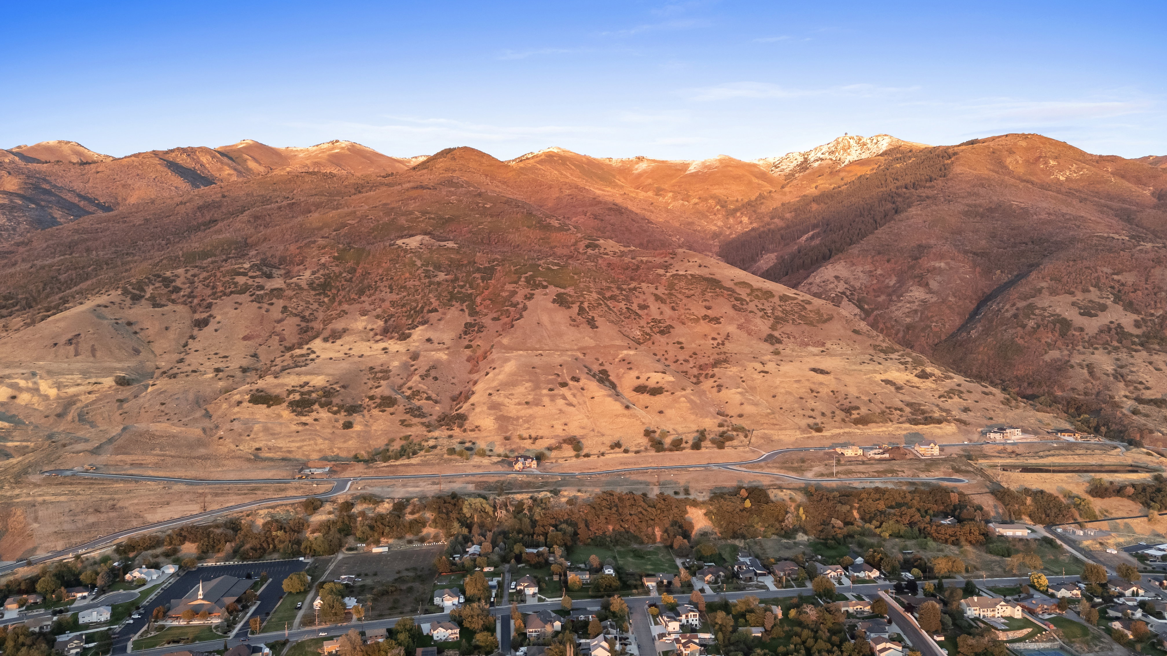 View of mountain backdrop featuring nearby suburban area