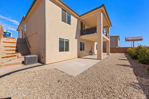 Back of property with stucco siding, a patio area, fence, a balcony, and cooling unit