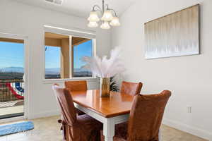 Dining area with light tile patterned floors, visible vents, baseboards, and an inviting chandelier