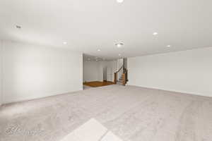 Interior space with carpet, visible vents, stairway, and recessed lighting