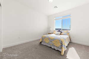 Carpeted bedroom featuring baseboards and visible vents