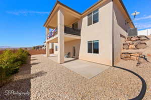 Rear view of property featuring a balcony, fence, a patio area, a mountain view, and stucco siding