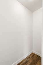 Unfurnished room featuring dark wood-type flooring and baseboards