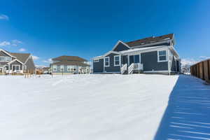 Snow covered property with fence