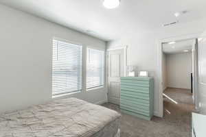 Bedroom with carpet floors, visible vents, and baseboards