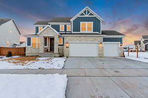 Craftsman inspired home with board and batten siding, fence, and driveway