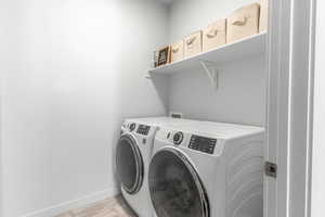 Laundry area with laundry area, washing machine and clothes dryer, and baseboards