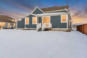 Snow covered house featuring fence