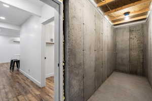 Unfinished basement with baseboards and wood finished floors