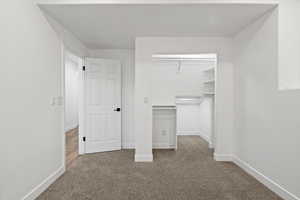 Unfurnished bedroom with a closet, carpet, and baseboards