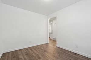 Spare room with wood finished floors, visible vents, and baseboards