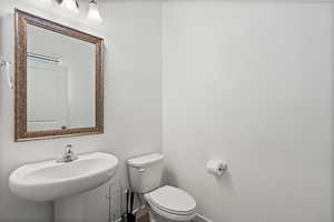 Bathroom with baseboards, a sink, and toilet