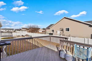 Wooden deck featuring a trampoline, a fenced backyard, and a residential view