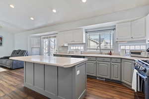 Kitchen with a center island, gray cabinets, light countertops, and a sink