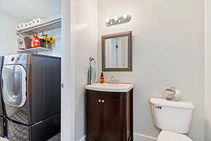 Bathroom with toilet, washer / dryer, and vanity