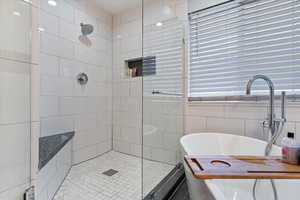 Bathroom featuring a freestanding bath and a tile shower