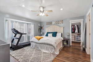 Bedroom featuring dark wood-style flooring, recessed lighting, a closet, a spacious closet, and a ceiling fan